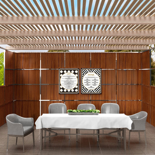 Modern wooden sukkah with 2 Piece Onyx Sukkah Decoration Set, a dining table with white tablecloth, and gray chairs.