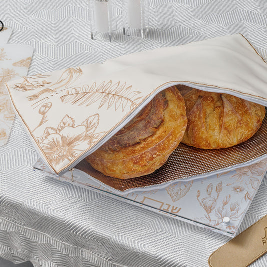 Freshly baked challah loaves wrapped in an Gold French Toile Challah Pouch Set.