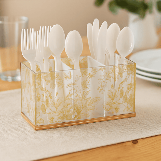 French Toile Silverware Caddy organizing white plastic forks, spoons, and knives on a dining table.