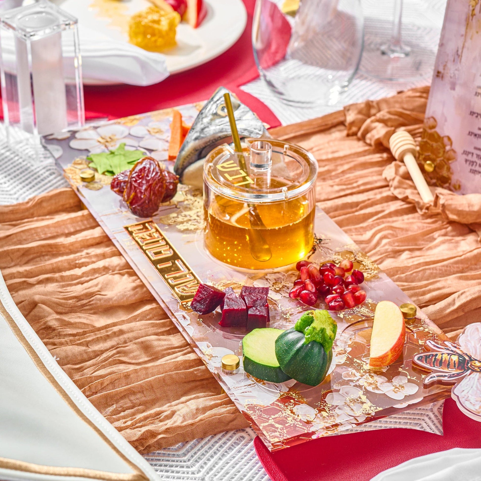 Honeycomb Simanim Tray with honey dish, fish head, and other items on top of it in a Rosh Hashanah table setting