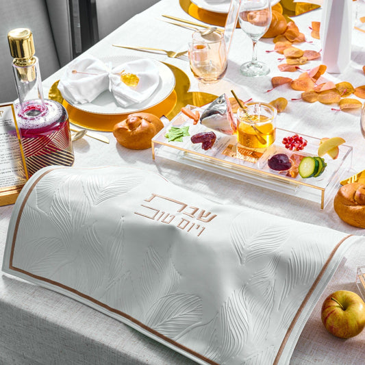 Leaf Challah Cover on a festive holiday table with gold tableware, honey, pomegranate seeds, and symbolic foods for Rosh Hashanah.