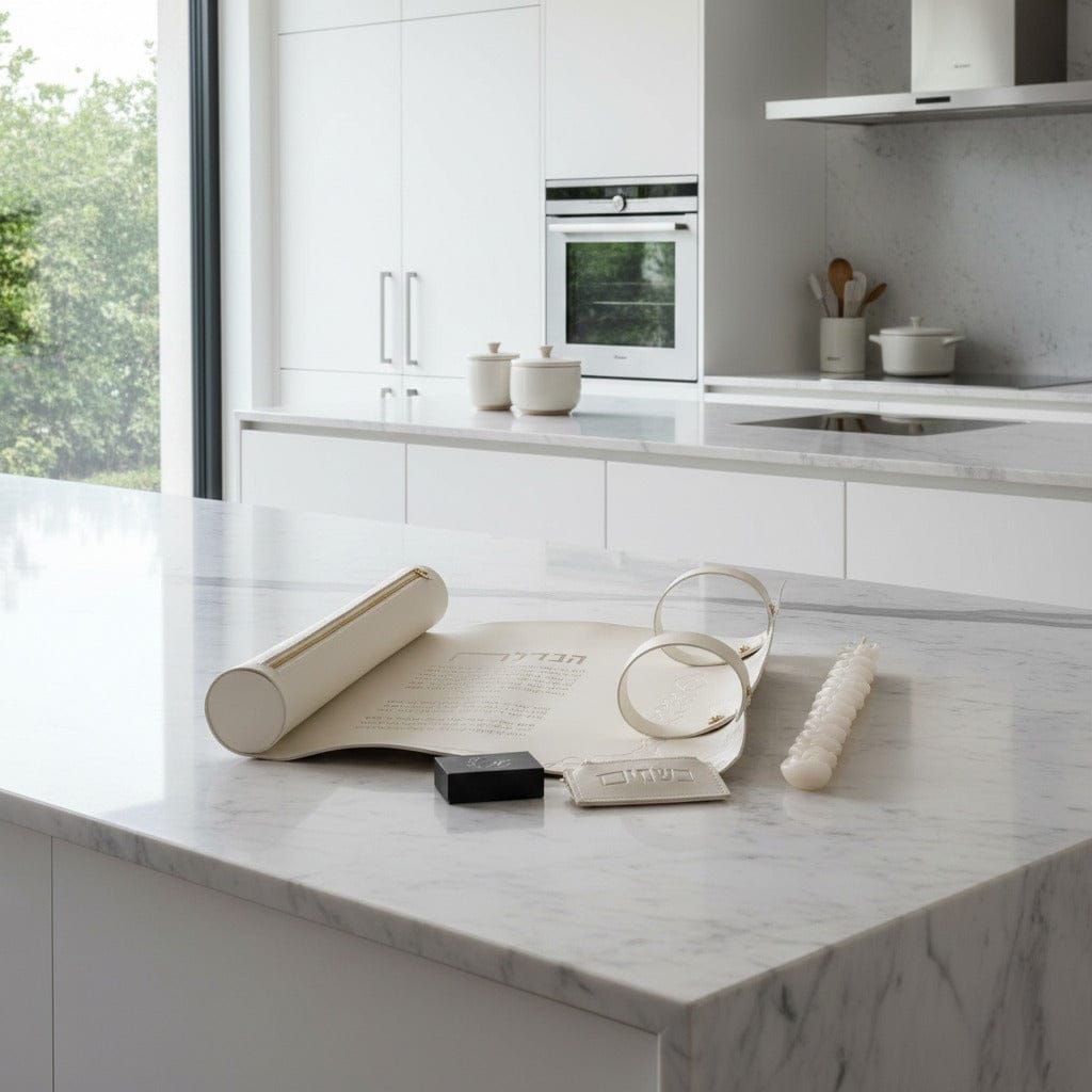 Luxury white leather Havdalah mat set with blessings, candle, spice box, and Kiddush cup rings on a modern white marble kitchen counter. - Waterdale Collection