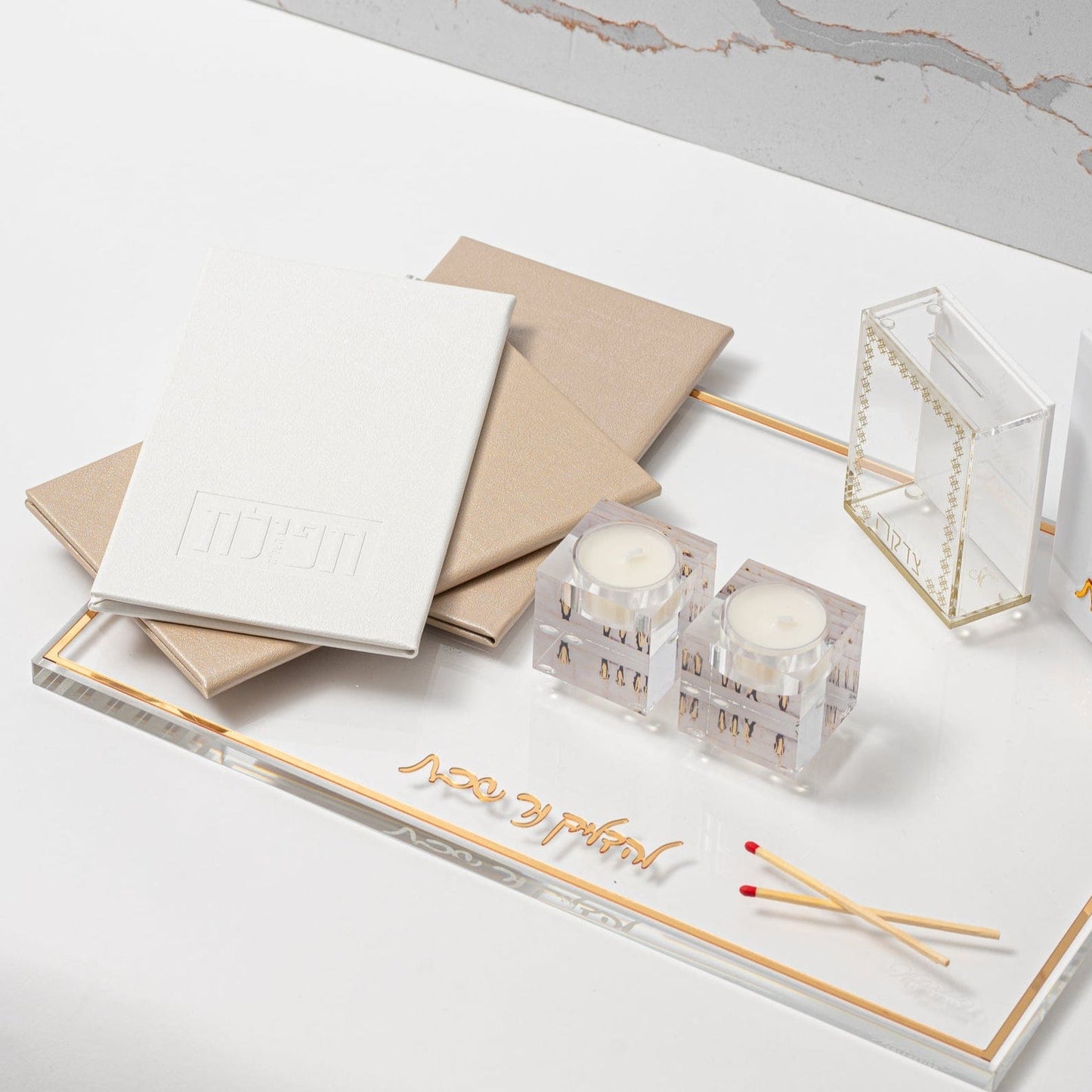 White and Gold Leather Tefillas Hashlah Book on top of a tray with tea light holder and matches | Waterdale Collection