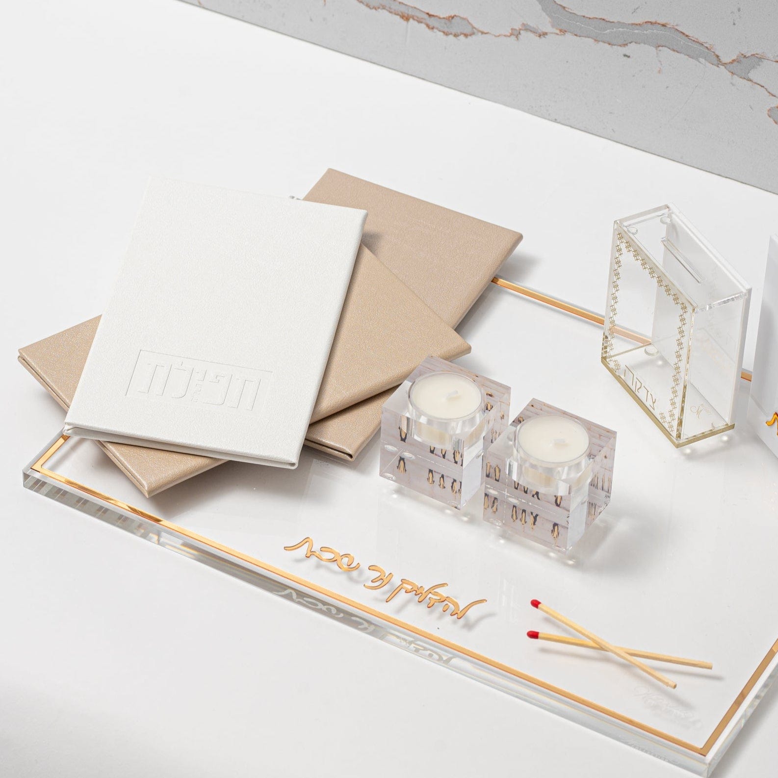 White and Gold Leather Tefillas Hashlah Book on top of a tray with tea light holder and matches | Waterdale Collection