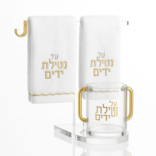 Luxury Netilat Yadayim Cup, Scalloped Towel & Stand Set. Gold-handled hand washing cup and Hebrew-embroidered towels on a clear stand in a modern bathroom - Waterdale Collection