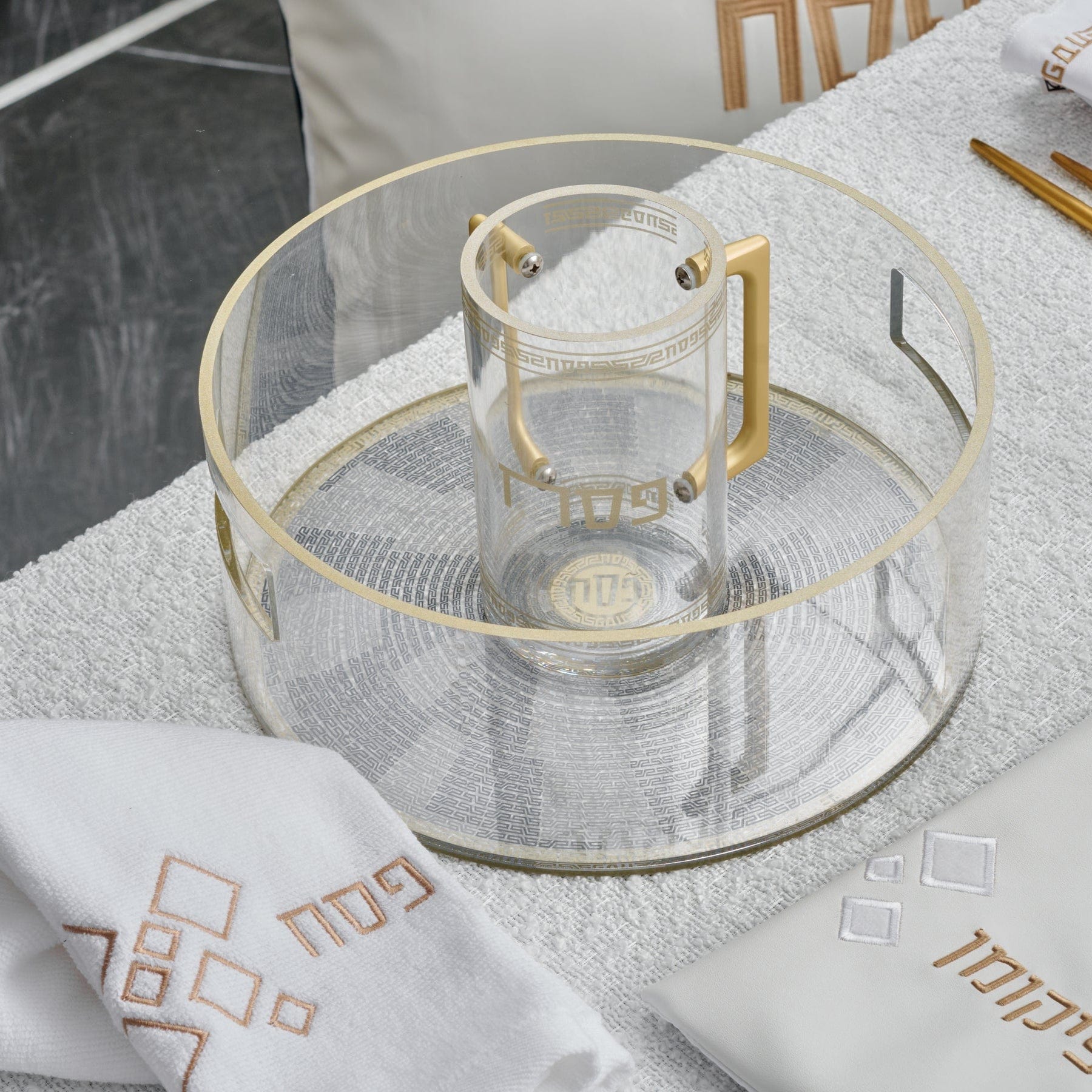 Gold accent Pesach Geometric Washing Bowl & Cup on top of a towel that's laid on a table | Waterdale Collection