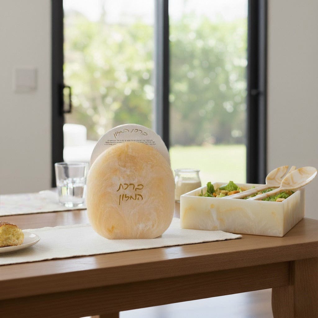 Marble resin bencher set displayed on a dining table beside a matching marble square salad bowl in a bright modern dining room.