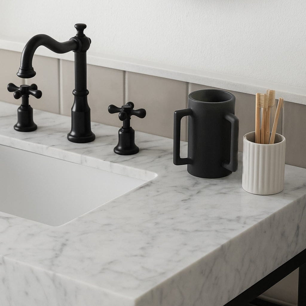 Matte black resin washing cup shown on a modern white marble bathroom vanity next to a black three-hole widespread faucet - Waterdale Collection