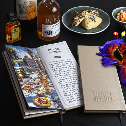 Gold Tall Leather Painted Megillas Esther book displayed with Purim treats, drinks, and a festive mask | Waterdale Collection